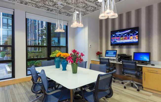 a conference room with a table and chairs and a tv on the wall at Ann Arbor City Club, Ann Arbor Michigan