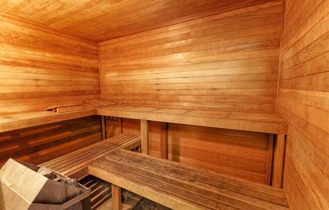 A wooden sauna with benches and a table.