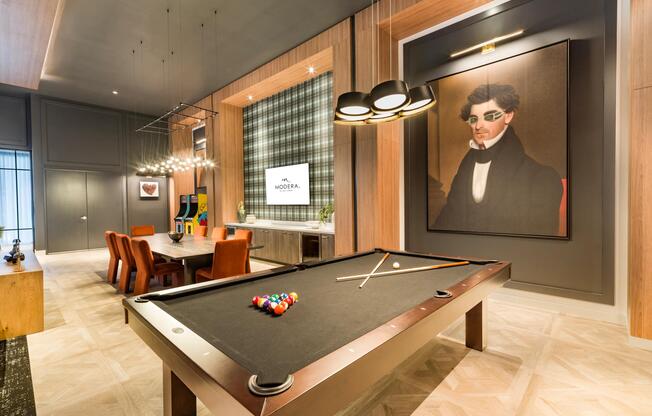 Warm wood detailing, tailored lighting, and curated artwork frame this billiards lounge, blending classic game-room elements with a polished, contemporary aesthetic.