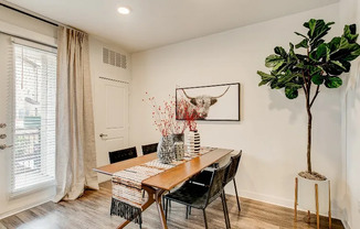 Luxury Grapevine TX apartment dining space with wood flooring and patio door.