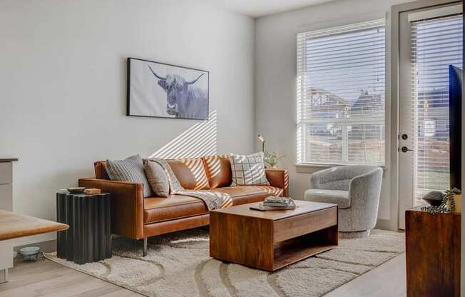 A living room with a brown leather couch and a coffee table.