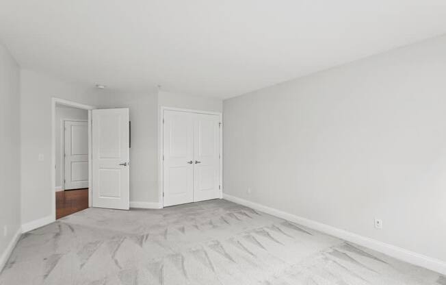 A room with two white doors and a carpeted floor.