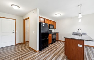 a kitchen with a black refrigerator and a counter top