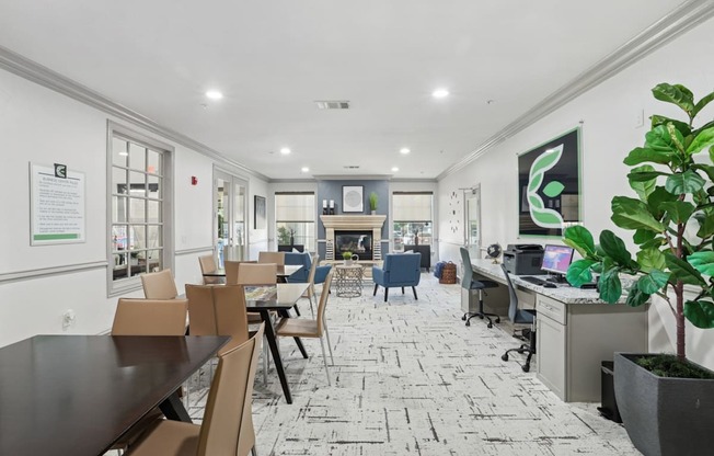 A business center with computers, tables and chairs, and a printer at Encore at Buckingham Apartments in Richardson, TX