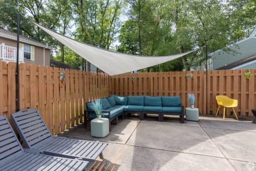 a patio with a blue couch and a canopy over it