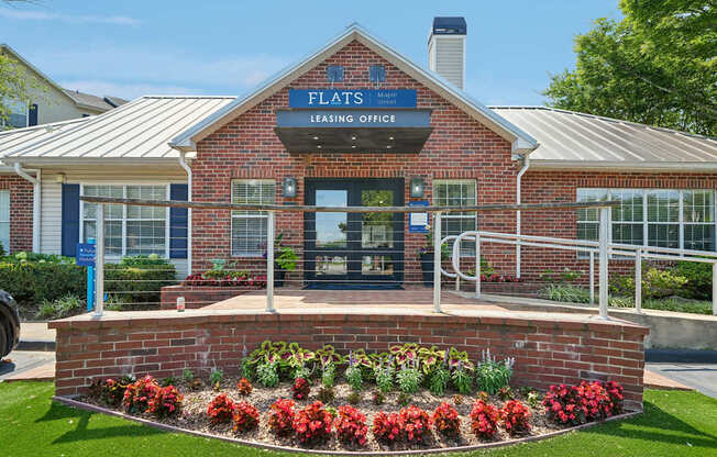 A brick building with a sign that says Flats Leasing Office.