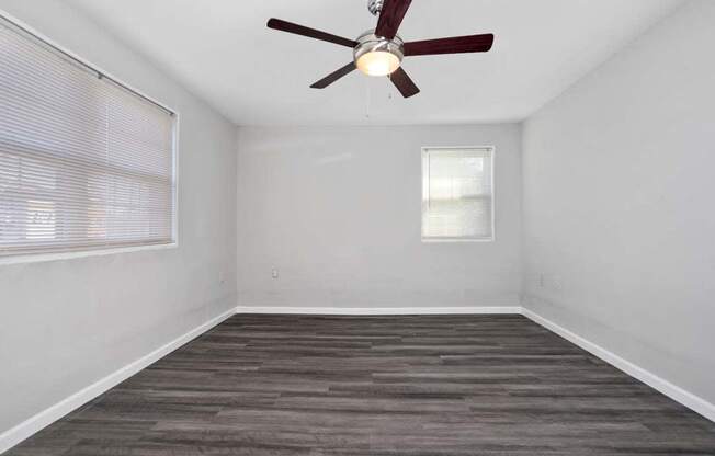 an empty room with a ceiling fan and a window