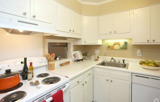 a kitchen with white cabinets and a stove and sink