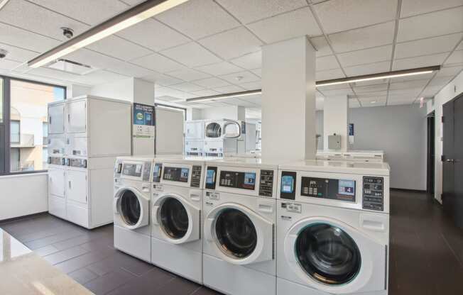a laundromat with a row of washing machines and dryers