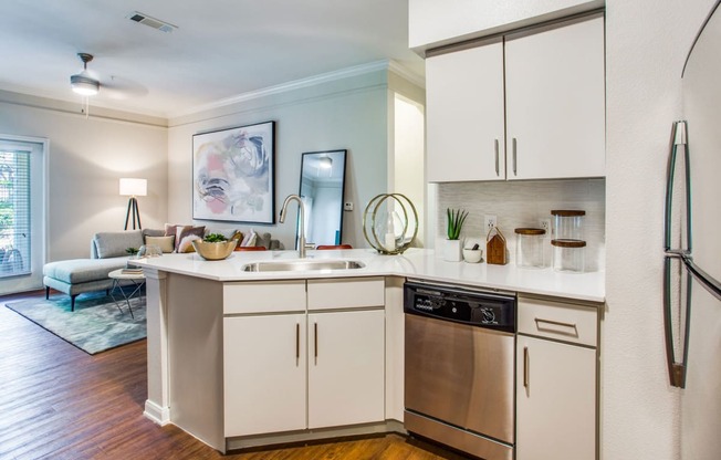 a kitchen with white cabinets and a sink and a dishwasher at Carrington at Barker Cypress, Cypress, TX, 77433