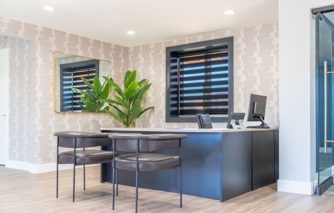 an office with two stools and a desk with a computer