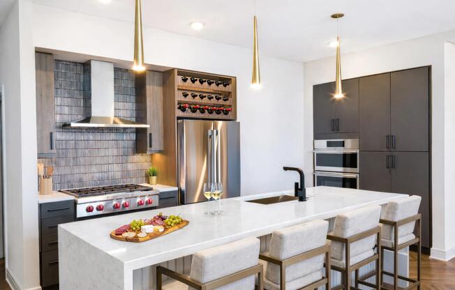 This penthouse kitchen features an expansive island, built-in wine storage, and design-forward finishes throughout.