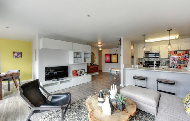 Living Room Kitchen and Dining Area with Hardwood Inspired Floor, Black Chair, Bar Seating and Black/White Rug