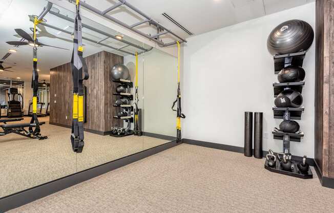 Resident gym with weight and mirrored walls at Sylvan Uptown, Denver