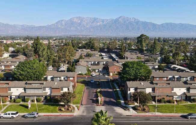 an aerial view of a neighborhood with houses and trees and mountains at Encore Apartments, Ontario, 91764