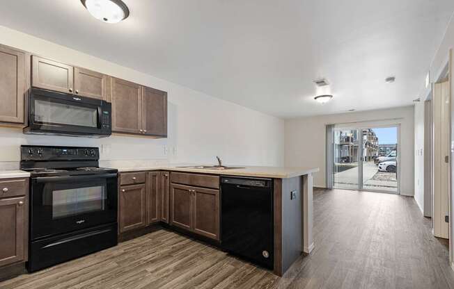 A kitchen with wooden cabinets and black appliances.