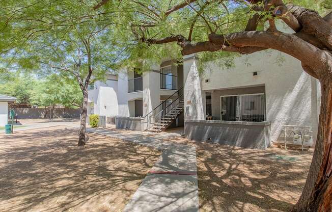 a building with a staircase and trees in front of it