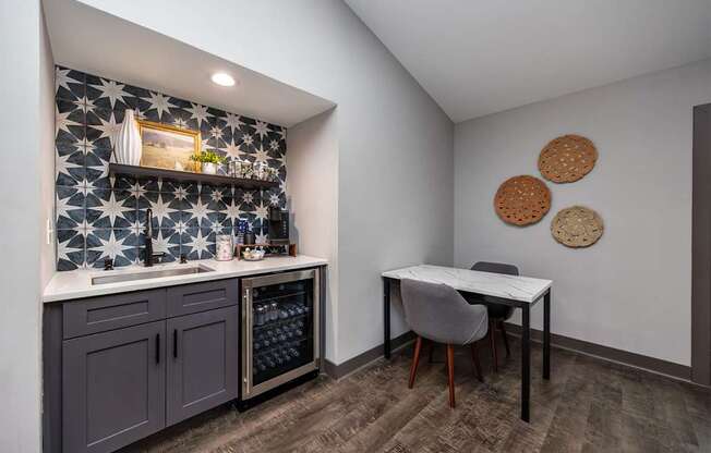 A kitchen with a tile backsplash and a table with chairs.