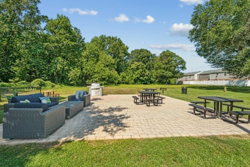 A sunny day at the park with picnic tables and loungers at Staples Mill Townhomes Apartments, Virginia