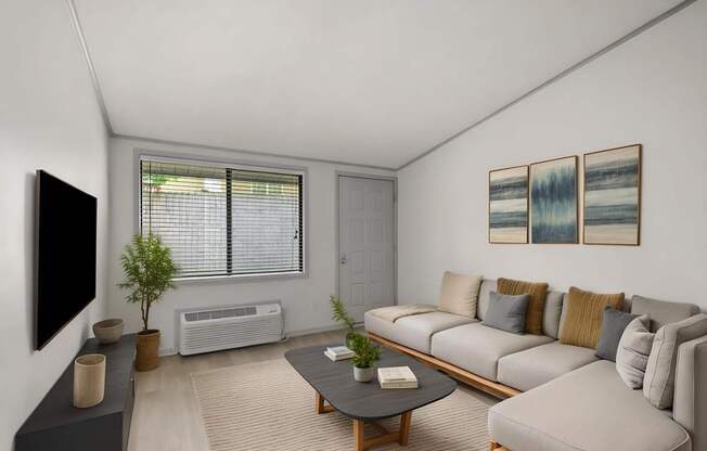 Retreat at Indian Lake apartments in Hendersonville, TN living room with a grey couch, a black coffee table, and a flat screen TV mounted on the wall.