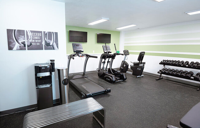 A gym with treadmills, weights and exercise equipment.