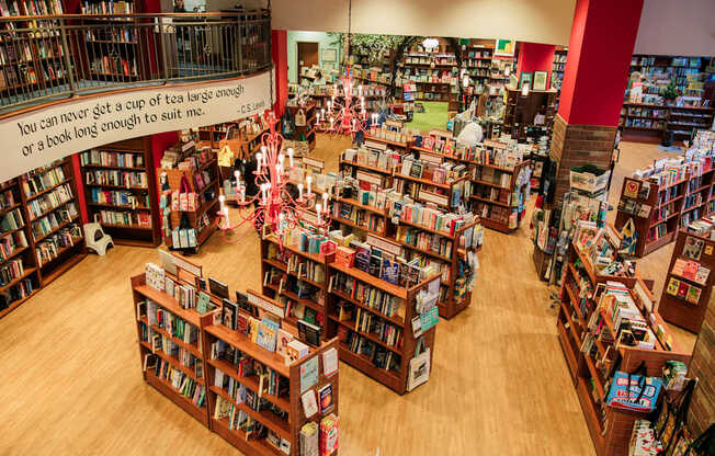 A book store with many book shelves and a sign that says you can never get a cup of tea large enough or a book long enough.