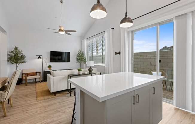 a kitchen island in a living room with a couch and a tv at Village of Chandler Apartments, Arizona, 85249