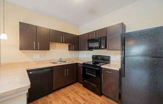 a kitchen with black appliances and wooden cabinets