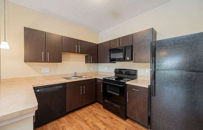 a kitchen with black appliances and wooden cabinets