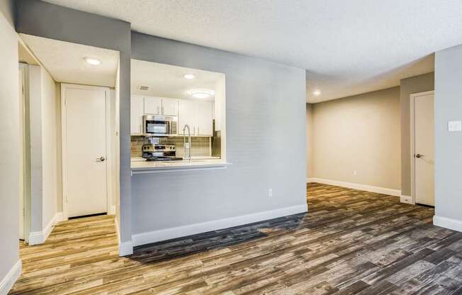 A room with wooden flooring and a mirrored wall.