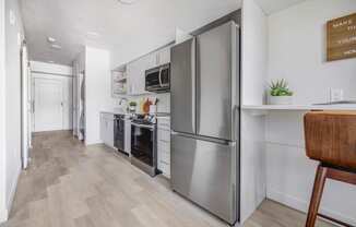 a kitchen with stainless steel appliances and a wooden floor