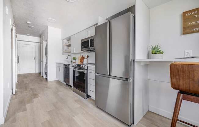 a kitchen with stainless steel appliances and a wooden floor