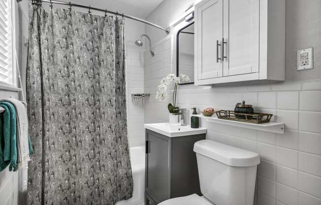 a bathroom with a white toilet next to a shower with a curtain  at Sunset Ridge, San Antonio, 78209