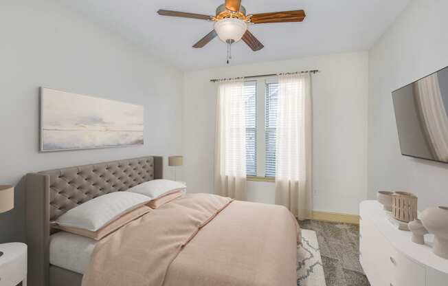 a bedroom with a bed and a ceiling fan