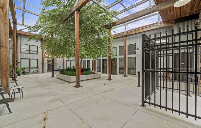 a courtyard with a metal gate and trees