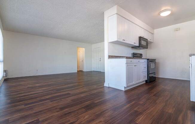 an empty kitchen and living room with hardwood floors at Park Avenue Apartments, California,90815
