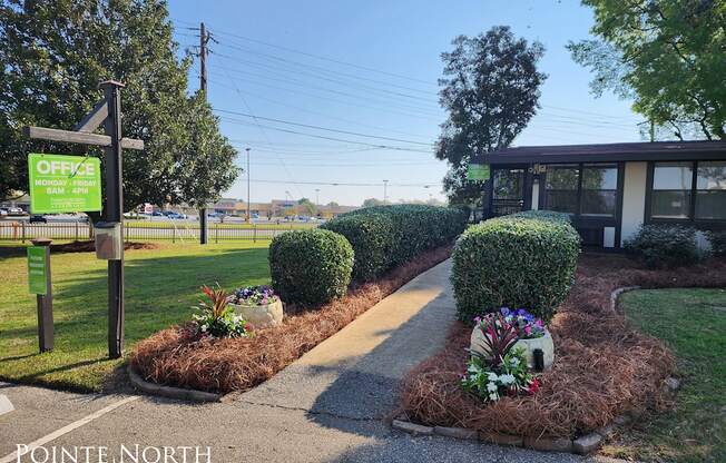 a sidewalk in front of a building with a green sign