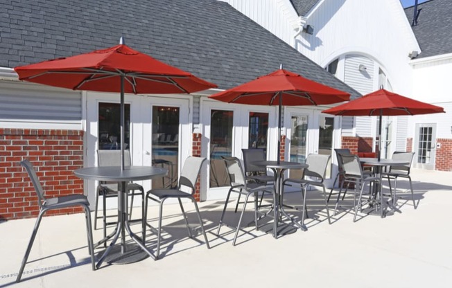 a patio with tables and umbrellas outside of a restaurant