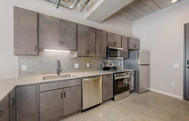 a kitchen with stainless steel appliances and a sink and a refrigerator