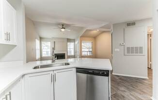 A kitchen with white cabinets and a stainless steel dishwasher.