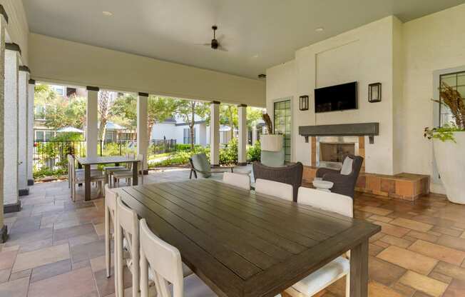 a dining room with a table and chairs and a fireplace at Summerwind, Pearland