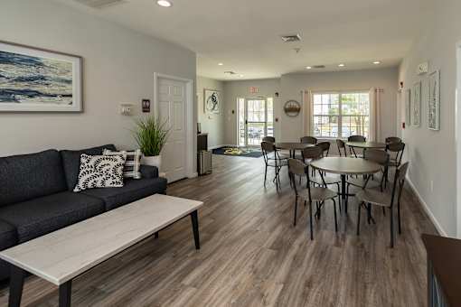 A living room with a couch, coffee table, and dining table.