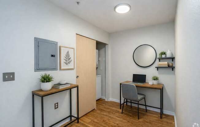 A room with a desk, chair, and a laptop.