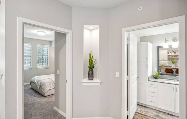 a bedroom and a bathroom with a bed and a mirror