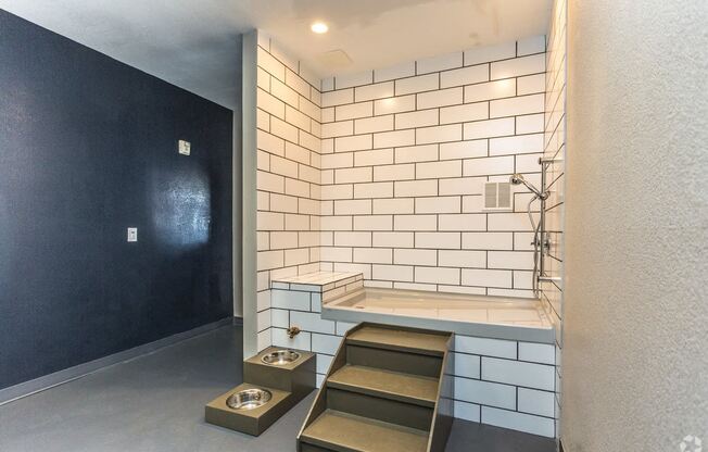 a small bathroom with white tiles and a black wall