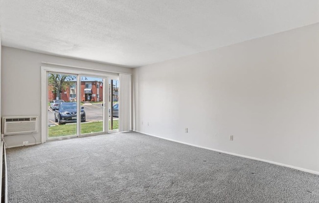 the living room of an empty apartment with a large window