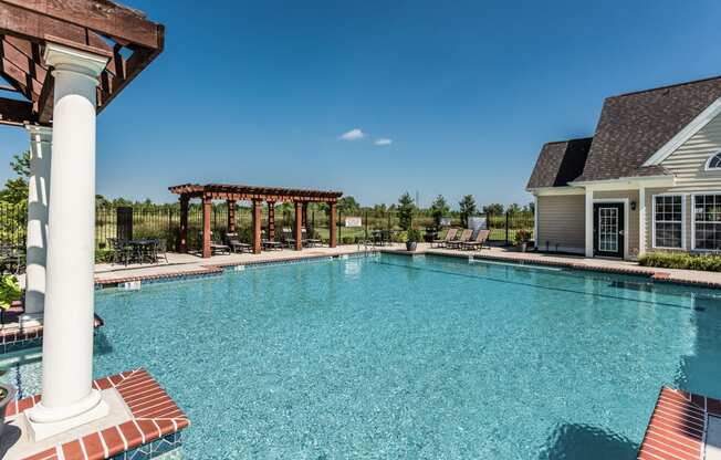 a large swimming pool with a house in the background