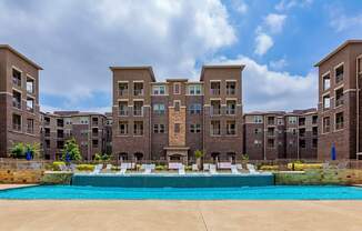 A large swimming pool in front of apartment buildings.