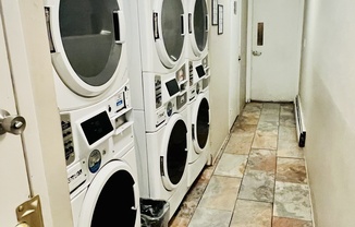 Bright laundry room with stacked washing and drying machines in a compact space.
