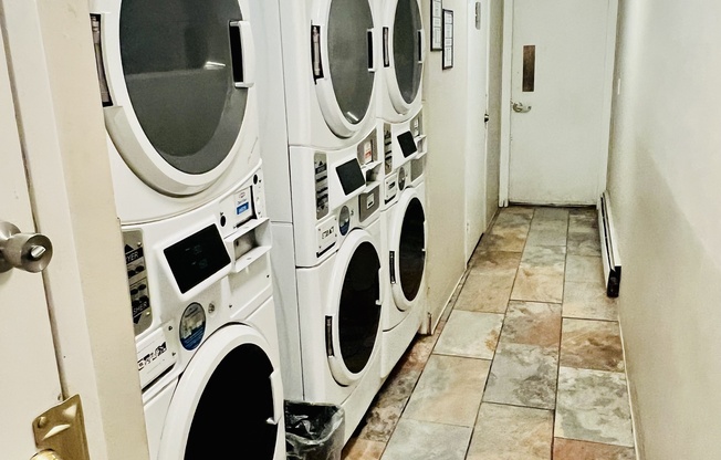 Bright laundry room with stacked washing and drying machines in a compact space.